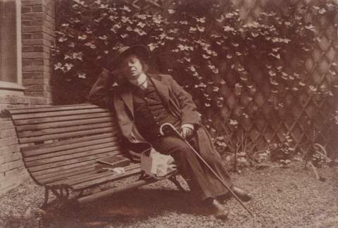 Henry de Groux zittend op een bank rond 1925